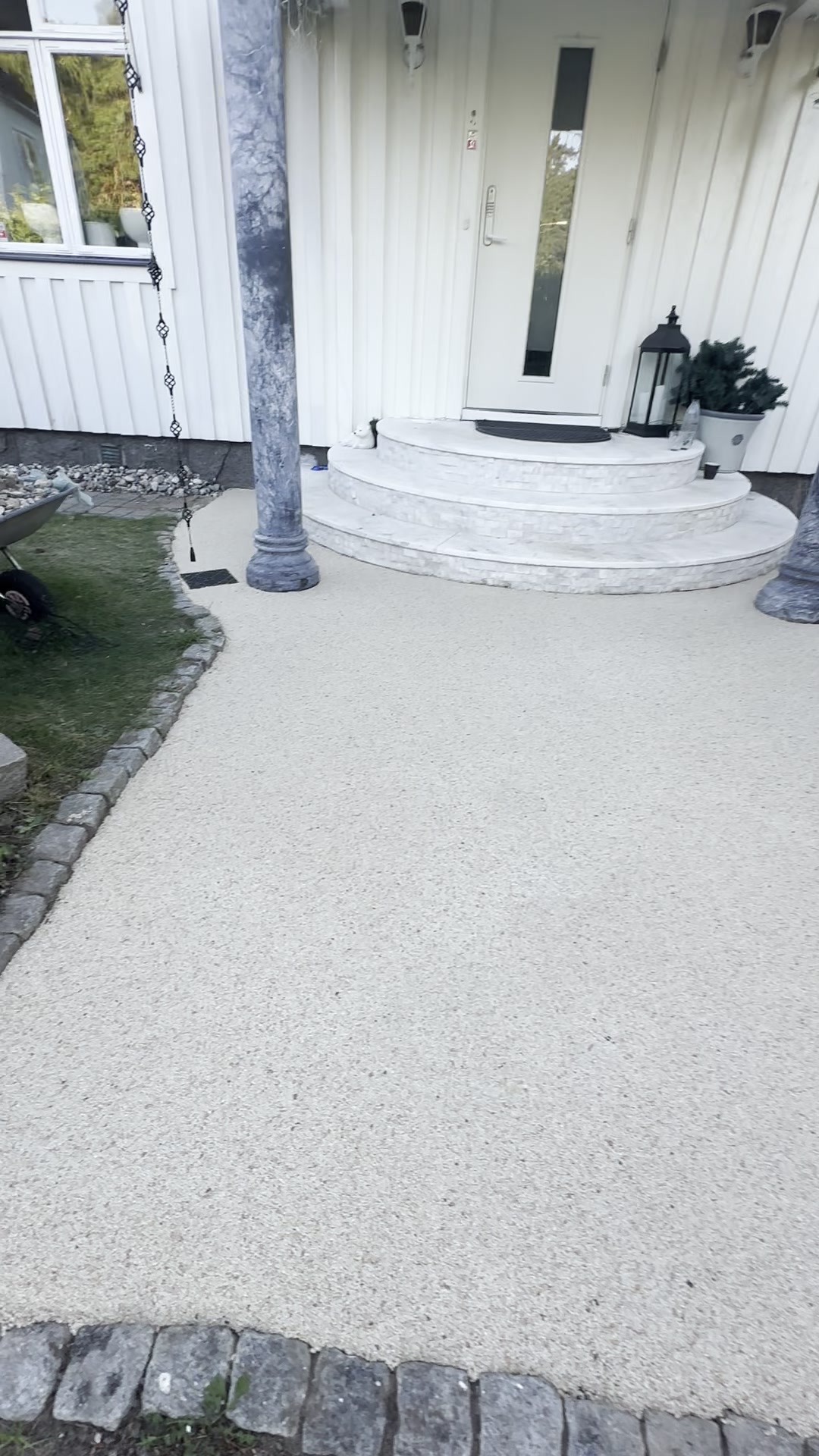 Färdig ljus stenmatta runt entré och rundad trappa